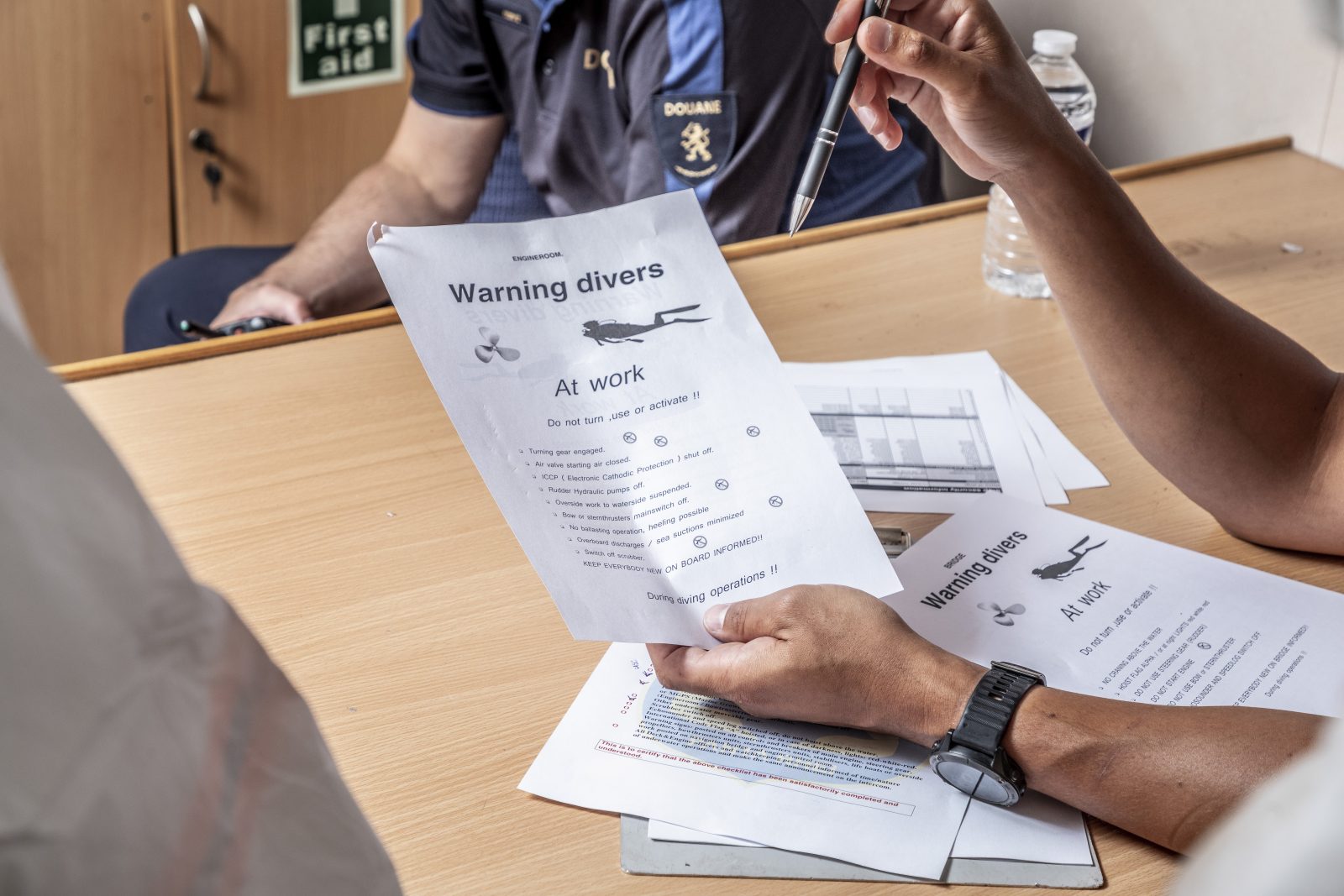 Iemand toont een checklist voor het werk van het duikteam van de Douane/