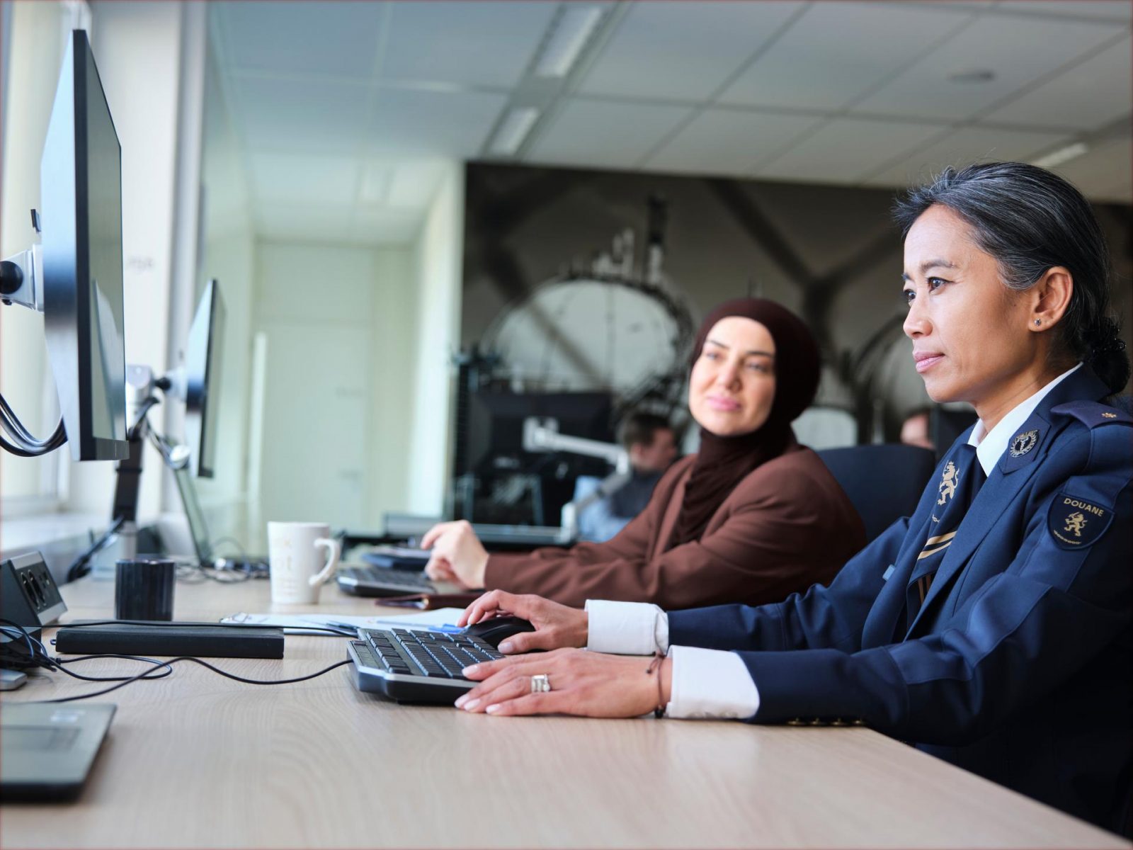 Medewerkers in het kantooruniform van de Douane.