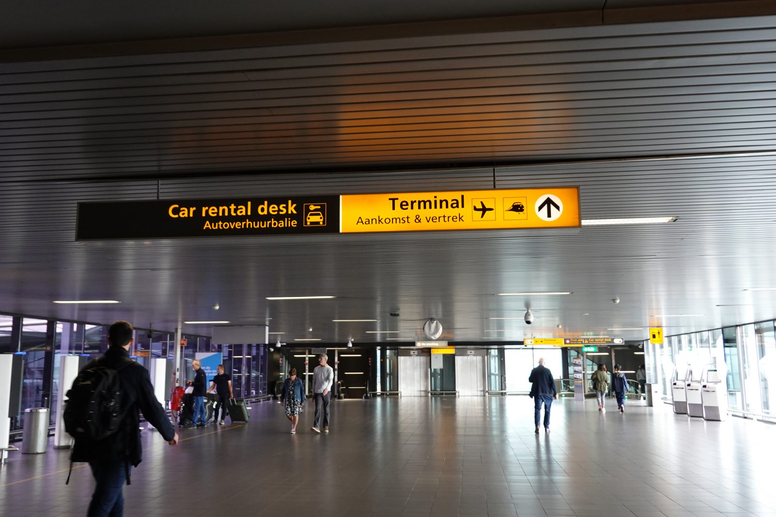 Een hal op Schiphol Airport met passagiers. 