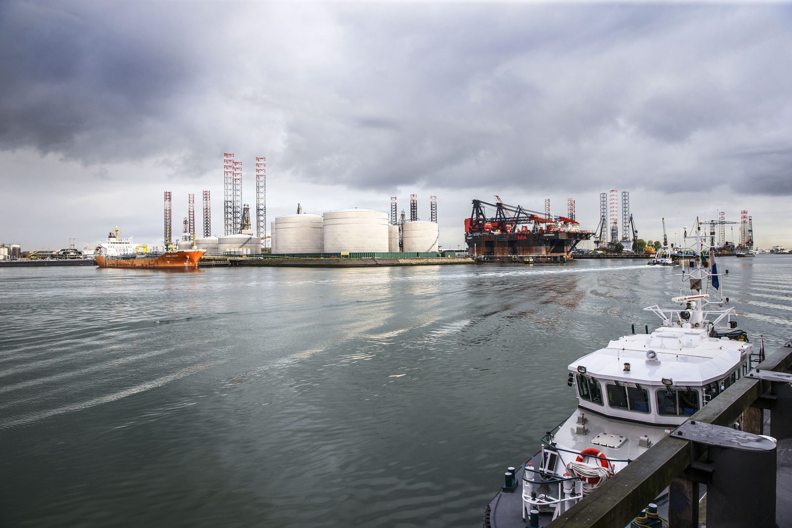 Eén van de havens op de Maasvlakte, met opslagtanks voor olie en en hijskranen. 