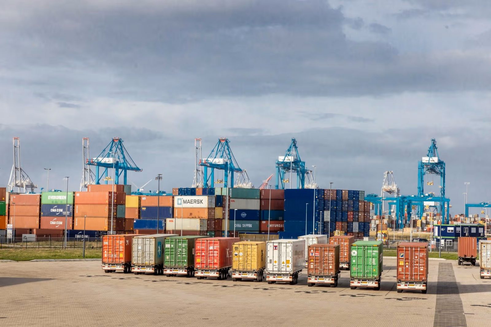 Een containerterminal, met vrachtwagens op de voorgrond. 