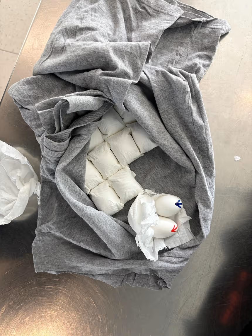 Een opengemaakt t-shirt, met eieren gewikkeld in papier.