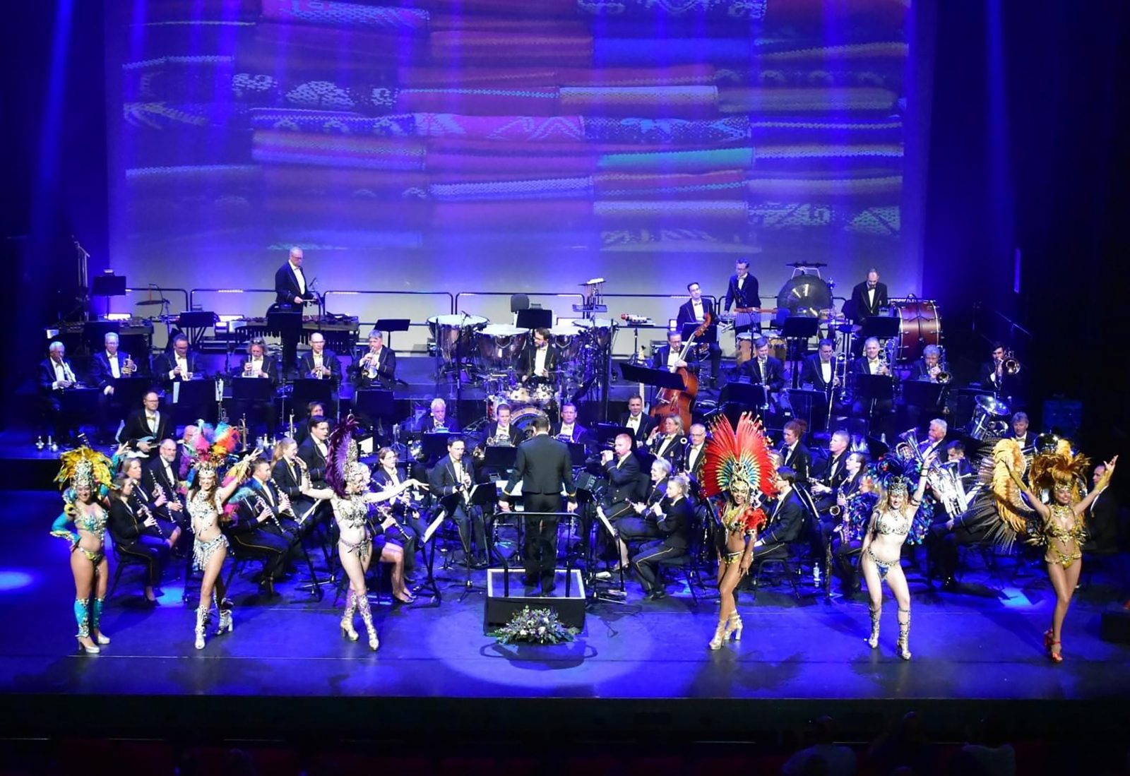 Het Nederlands Douane Orkest, met carnavalsdanseressen in verentooien.