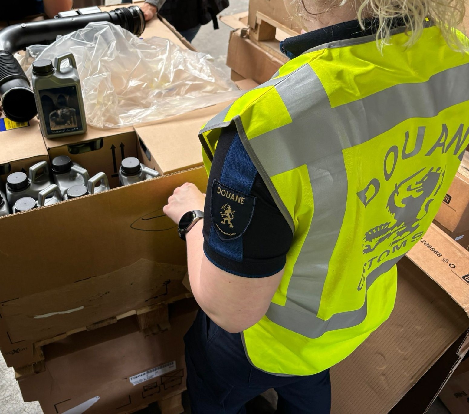 Douane-medewerker controleert kartonnen doos met goederen.